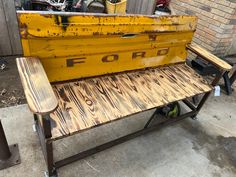 a yellow bench sitting next to a brick wall