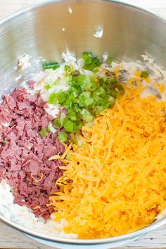 the ingredients for this dish are mixed together in a large metal bowl on top of a wooden table