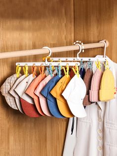 a rack with hats hanging from it next to a coat rack on a wooden wall