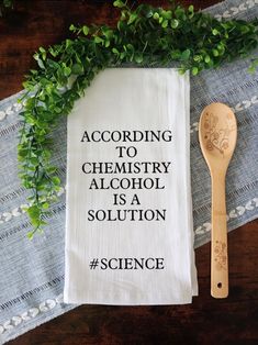 a tea towel with the words according to chemistry alcohol is a solution on it next to a wooden spoon