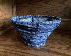 a small blue basket sitting on top of a wooden table