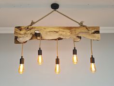 a light fixture made out of wood with five bulbs hanging from it's sides