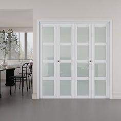 a dining room with white walls and glass doors