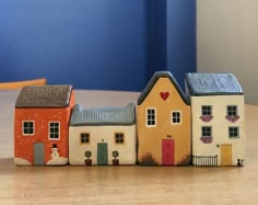 three small houses sitting on top of a wooden table