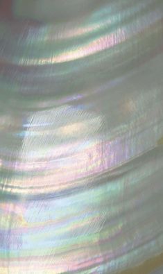 a close up view of an iridescent object with blurry lines on it