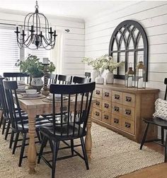 the dining room table is set with black chairs and an oval mirror on the wall