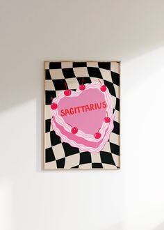 a pink heart shaped cake sitting on top of a black and white checkered wall