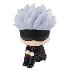 a figurine is sitting on the ground wearing a blindfold