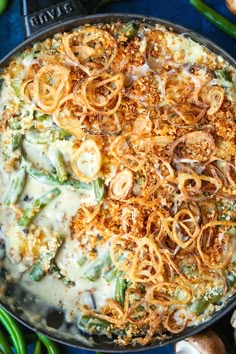 a casserole dish with cheese, onions and green beans