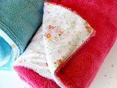 three towels folded on top of each other with flowers and leaves printed on them, sitting next to each other