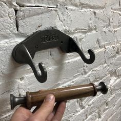 a person is holding an umbrella hook on a brick wall