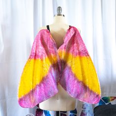 a pink, yellow and purple tie dyed shawl on a mannequin head