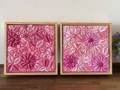 two wooden frames with pink paper flowers on them