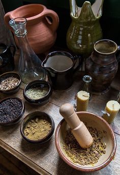 an assortment of spices and condiments sit on a table next to vases