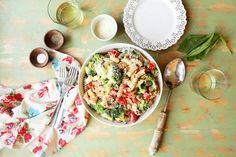 a bowl of pasta with spinach, tomatoes and parmesan cheese on the side