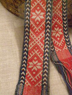 a red and blue tie sitting on top of a white table next to a wooden bowl