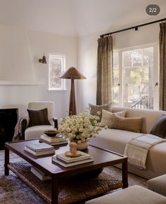 a living room filled with furniture and a fire place next to a window covered in curtains