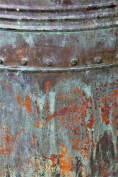 an old rusted metal container with rivets on the outside and red paint all over it