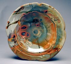 a glass plate that is sitting on a table with an orange and blue design in the center