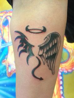 a black and white tattoo on the leg of a person with an angel wings design