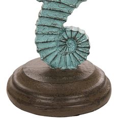 a small blue seahorse on a wooden base