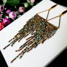 a pair of earrings with beads hanging from them