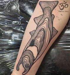 a black and white photo of a shark tattoo on the arm