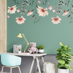 a desk with a chair, potted plant and stuffed animal on it in front of a green wall