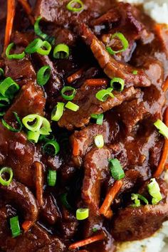 a close up of food on a plate with rice and green onion garnish