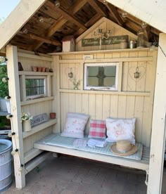 a wooden bench with pillows on it in a garden shed or patio area that is made out of wood planks