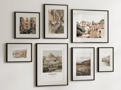 a bunch of pictures hanging on the wall with frames around them that are displaying buildings