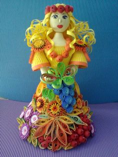 a figurine made out of paper with flowers on it