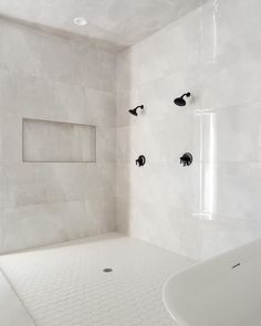 a white tiled bathroom with an open shower