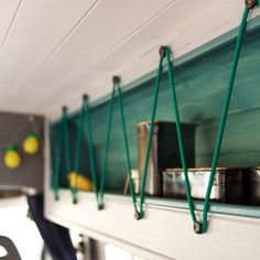 the shelves are filled with pots, pans and other kitchen items hanging on the wall