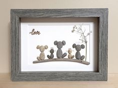 three pebbles are sitting on a shelf with a flower in the middle and two small rocks behind them