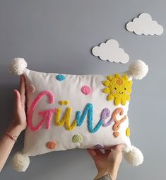 someone holding up a pillow with the word game on it and pom poms