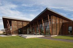 a modern building with wooden slats on the side and grass in front of it