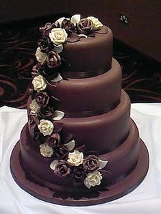 a three tiered chocolate wedding cake with white flowers