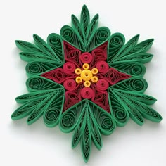 an ornament made out of green paper with red and yellow flowers on it