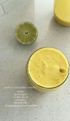 a glass filled with orange juice next to two limes on a counter top, and the words today's smoothie comes