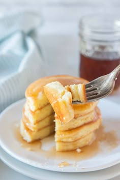 a stack of pancakes with syrup being drizzled on top