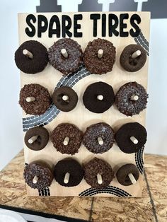 a wooden sign with donuts on it that says spare tires and is decorated with chocolate frosting