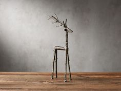 a metal deer sculpture sitting on top of a wooden table