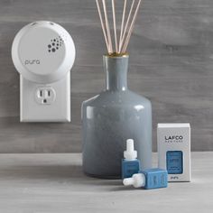 an air freshener and diffuser next to a bottle with reeds in it