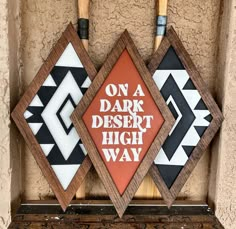 three wooden signs with different designs on them