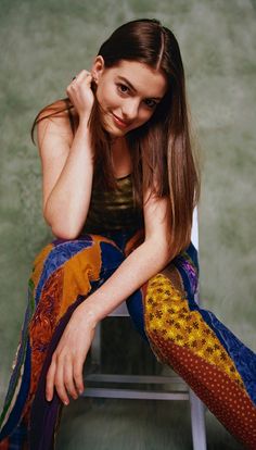 a young woman sitting on top of a white chair