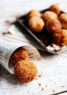 some food that is sitting on a table next to a newspaper and bowl with it's contents