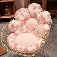 a chair with pink and white flowers on it's seat cushion in a living room