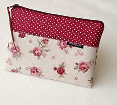 a red and white flowered pouch with polka dots on it, sitting on a table