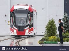 a man standing in front of a red and white train